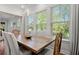 Sunlit dining room featuring large windows, hardwood floors, and a rustic wooden table and chairs at 3010 Emma Ln, Mount Pleasant, SC 29466