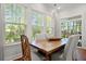Bright dining area with large windows, hardwood floors, and rustic wooden table and chairs at 3010 Emma Ln, Mount Pleasant, SC 29466