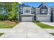 Townhome exterior features a long driveway, two-car garage, neutral colors, manicured lawn, and professionally landscaped shrubs at 3010 Emma Ln, Mount Pleasant, SC 29466