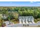 A row of newly constructed townhomes with attached garages surrounded by mature trees against a bright blue sky at 3010 Emma Ln, Mount Pleasant, SC 29466