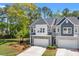 Two-story townhome with a two-car garage, long private driveway, green lawn, and manicured landscaping at 3010 Emma Ln, Mount Pleasant, SC 29466