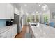 Open kitchen featuring white cabinetry, stainless appliances, island seating, and hardwood floors at 3010 Emma Ln, Mount Pleasant, SC 29466