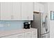Close-up of kitchen featuring stainless fridge, white cabinets, and quartz countertops at 3010 Emma Ln, Mount Pleasant, SC 29466