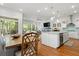 Open-concept kitchen with white cabinets, stainless steel appliances, island with bar seating, and hardwood floors at 3010 Emma Ln, Mount Pleasant, SC 29466