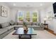 Comfortable living room with a large sectional sofa, hardwood floors, and a large window overlooking a manicured yard at 3010 Emma Ln, Mount Pleasant, SC 29466