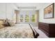 Comfortable main bedroom featuring a dark wood bed frame, neutral walls, tray ceiling, and three large windows for plenty of natural light at 3010 Emma Ln, Mount Pleasant, SC 29466