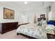 Comfortable main bedroom featuring a dark wood bed frame, neutral walls, tray ceiling, and multiple windows for plenty of natural light at 3010 Emma Ln, Mount Pleasant, SC 29466