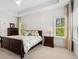Comfortable main bedroom featuring a dark wood bed frame, neutral walls, tray ceiling, and multiple windows for plenty of natural light at 3010 Emma Ln, Mount Pleasant, SC 29466