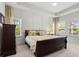 Comfortable main bedroom featuring a dark wood bed frame, neutral walls, tray ceiling, and multiple windows for plenty of natural light at 3010 Emma Ln, Mount Pleasant, SC 29466