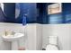 Charming powder room featuring blue shiplap walls, white wainscoting, and a modern round mirror above a pedestal sink at 3010 Emma Ln, Mount Pleasant, SC 29466