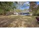 Spacious backyard showcasing a well-maintained lawn, mature trees, and a charming deck area, perfect for outdoor enjoyment at 306 Teakwood Dr, Walterboro, SC 29488