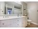 Bathroom with double sinks, white cabinets, large mirror and a tiled floor at 306 Teakwood Dr, Walterboro, SC 29488