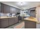 A well-lit kitchen featuring gray cabinets, stainless steel appliances, and a tile backsplash at 306 Teakwood Dr, Walterboro, SC 29488
