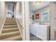 Functional laundry area with modern washer and dryer, complemented by nearby stairs and natural light from a window at 306 Teakwood Dr, Walterboro, SC 29488
