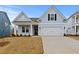 Charming light blue home with a two-car garage and manicured lawn on a sunny day at 347 Wappoo Trace Ln, Summerville, SC 29486