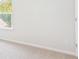 Bright bedroom with neutral carpet and white walls with trim, featuring a window and electrical outlets at 348 Dickerson Ln, Lincolnville, SC 29485