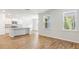 Open-concept living space with natural light, hardwood floors, and a view of the modern kitchen at 348 Dickerson Ln, Lincolnville, SC 29485