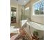 Bright bathroom with a freestanding tub, walk-in shower, and a large window offering scenic views at 4155 Jean Laffite Rd, Hollywood, SC 29449