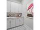Well-organized laundry room with stylish starburst floor tile, white cabinets and ample counter space at 4155 Jean Laffite Rd, Hollywood, SC 29449