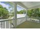 This inviting porch offers scenic views framed by white pillars and railings, perfect for outdoor relaxation and enjoying the landscape at 4155 Jean Laffite Rd, Hollywood, SC 29449