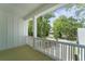 Covered porch offers a serene outdoor view framed by white railings and pillars, perfect for relaxation and enjoying the scenery at 4155 Jean Laffite Rd, Hollywood, SC 29449