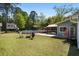 Spacious backyard featuring a swimming pool, deck, an outdoor seating area, mature trees and a playhouse at 4429 Highway 162, Hollywood, SC 29449