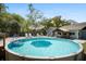 Above-ground pool with a sun umbrella surrounded by lounge chairs on a wooden deck in a lush backyard at 4429 Highway 162, Hollywood, SC 29449