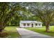 Quaint brick home with new metal roof, windows, and shutters, framed by mature trees and a long driveway at 463 E Main Street, Harleyville, SC 29448