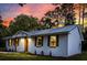 Evening view of a renovated brick home highlighting its new windows, shutters, and inviting entrance at 463 E Main Street, Harleyville, SC 29448