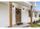 Close up of charming front porch showcasing new door, wreath, updated lighting, and brick detail at 463 E Main Street, Harleyville, SC 29448