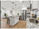 Open-concept kitchen flows into the living room, featuring a kitchen island, stainless steel appliances, and modern finishes at 463 E Main Street, Harleyville, SC 29448