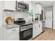 Close-up of the modern kitchen featuring granite countertops, stainless steel appliances, and white cabinets at 463 E Main Street, Harleyville, SC 29448