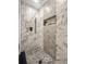 Luxurious walk-in shower with stunning marble tiles, a niche for storage, and modern fixtures at 463 E Main Street, Harleyville, SC 29448