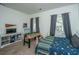 Bright bedroom with a foosball table, a bed with a colorful blanket, and neutral walls at 5009 W Liberty Park Cir, North Charleston, SC 29405