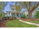 Charming two-story home with inviting front porch and landscaped yard, surrounded by mature trees and lush greenery at 5009 W Liberty Park Cir, North Charleston, SC 29405