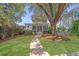 Charming two-story home with inviting front porch and landscaped yard, surrounded by mature trees and lush greenery at 5009 W Liberty Park Cir, North Charleston, SC 29405