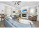 Bright living room with hardwood floors, fireplace, large windows, and comfortable seating, creating a cozy and inviting space at 5009 W Liberty Park Cir, North Charleston, SC 29405