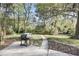 Picturesque backyard with large trees and greenery, a grill, and a concrete patio at 506 Fairington Dr, Summerville, SC 29485