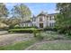 Charming two-story traditional home featuring a lush landscaped front yard with mature trees, stone bench, and walkway at 506 Fairington Dr, Summerville, SC 29485