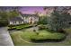 Charming two-story traditional home featuring a lush landscaped front yard with mature trees and manicured hedges at 506 Fairington Dr, Summerville, SC 29485