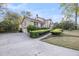 Charming two-story traditional home featuring a lush landscaped front yard with mature trees and a long paved driveway at 506 Fairington Dr, Summerville, SC 29485