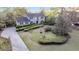 Charming two-story traditional home featuring a lush landscaped front yard with mature trees and manicured hedges at 506 Fairington Dr, Summerville, SC 29485