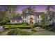 Charming two-story traditional home featuring a lush landscaped front yard with mature trees and manicured hedges at 506 Fairington Dr, Summerville, SC 29485