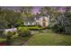 Charming two-story traditional home featuring a lush landscaped front yard with mature trees and manicured hedges at 506 Fairington Dr, Summerville, SC 29485
