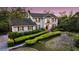 Charming two-story traditional home featuring a lush landscaped front yard with mature trees and manicured hedges at 506 Fairington Dr, Summerville, SC 29485
