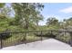Outdoor patio area with black metal railing and lush green trees in the background at 506 Fairington Dr, Summerville, SC 29485