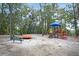 Playground equipment featuring slides, swings, and a merry-go-round amidst mature trees at 506 Fairington Dr, Summerville, SC 29485