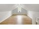 Bright attic space with wood flooring, neutral walls, and a window with an air conditioner at 509 Hill St, Moncks Corner, SC 29461