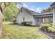 View of the backyard featuring wood siding, mulched flowerbeds and healthy green grass at 509 Hill St, Moncks Corner, SC 29461