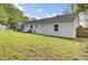 View of the house from the backyard with a well-maintained lawn and mature trees at 509 Hill St, Moncks Corner, SC 29461